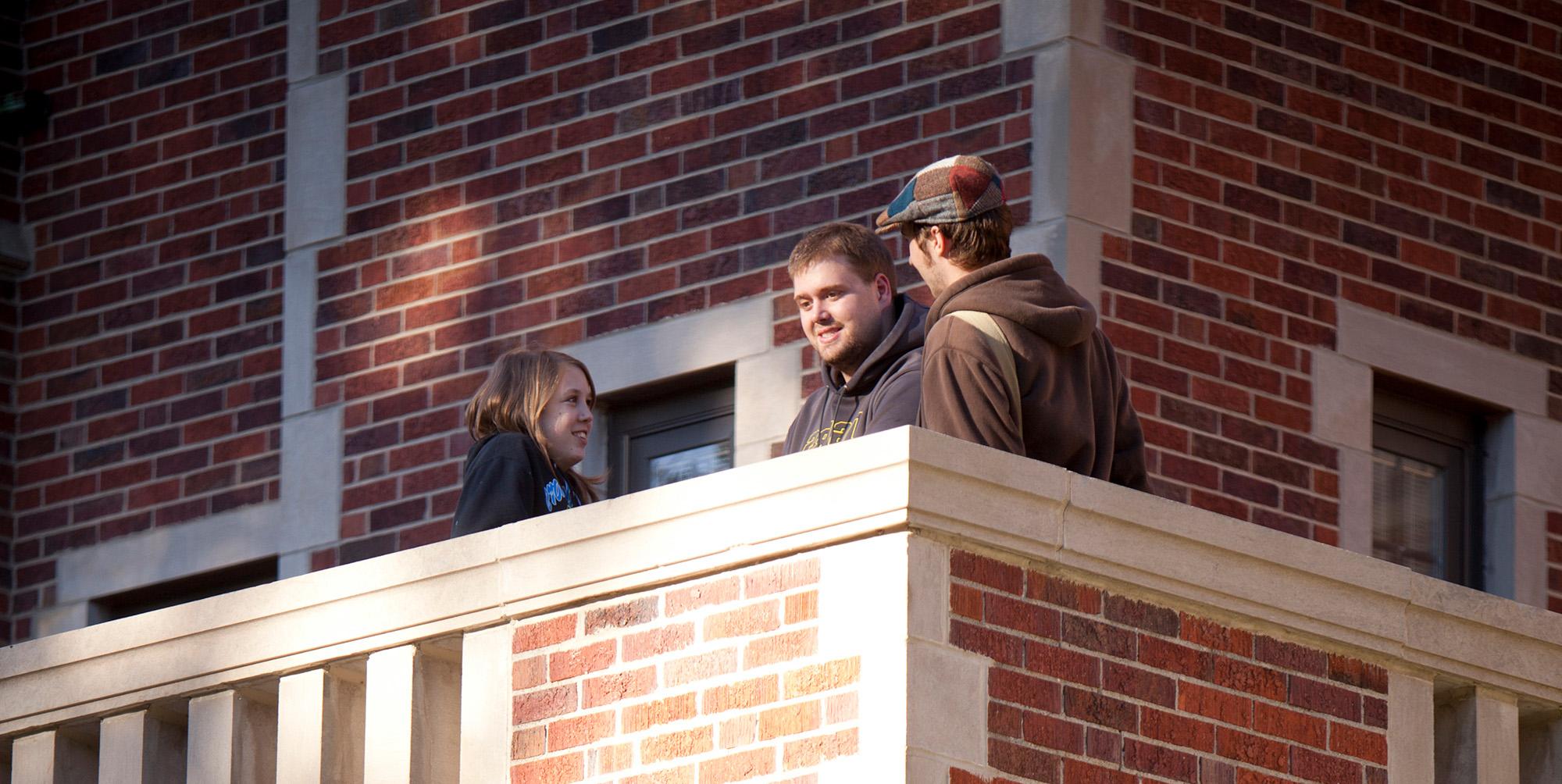 Students talking on a balcony at Fees Hall